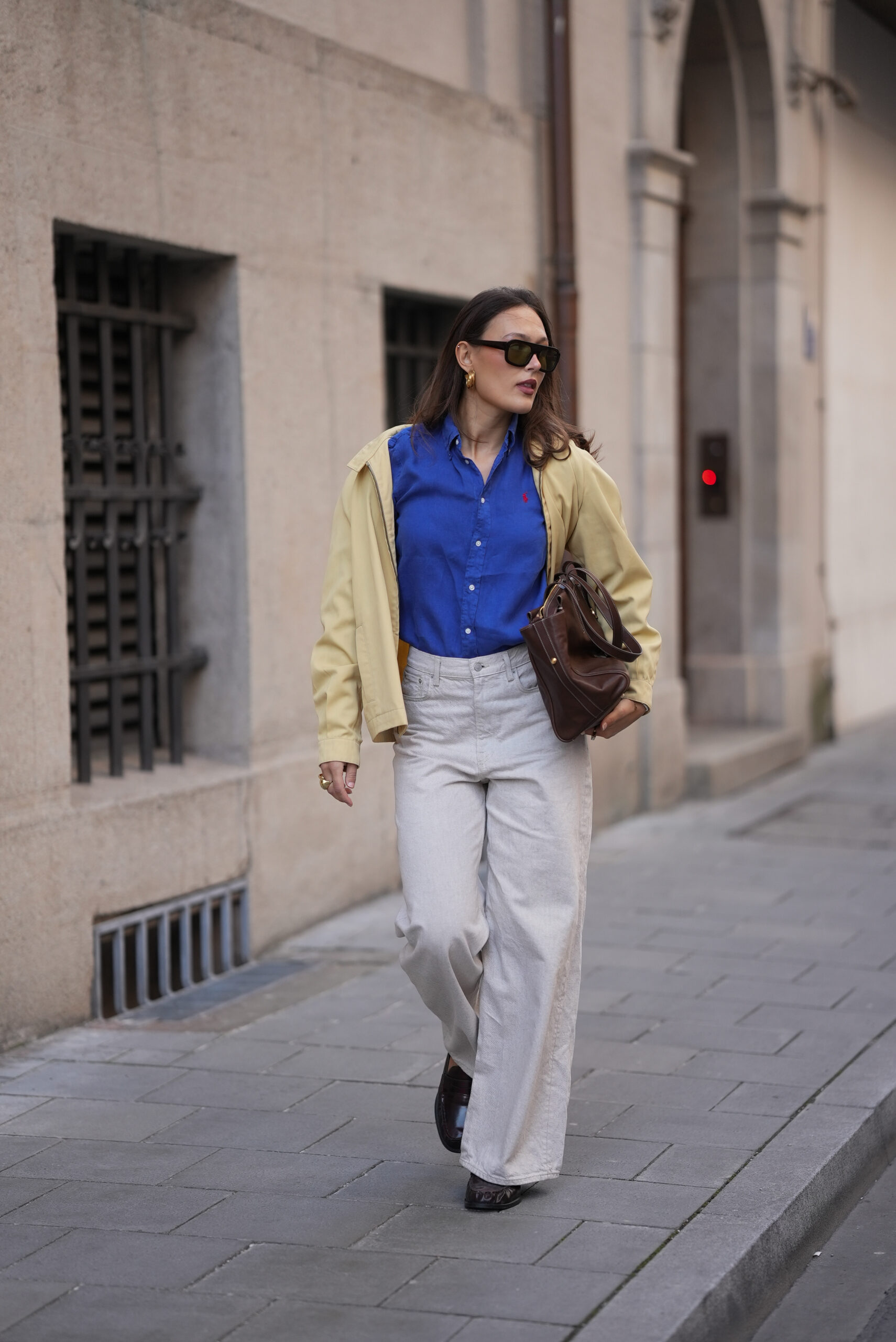 Amanda Mühle wearing a light yellow zip front jacket with a relaxed fit and pointed collar from Fred Perry; a cobalt blue cotton button up shirt with a classic collar from Polo Ralph Lauren