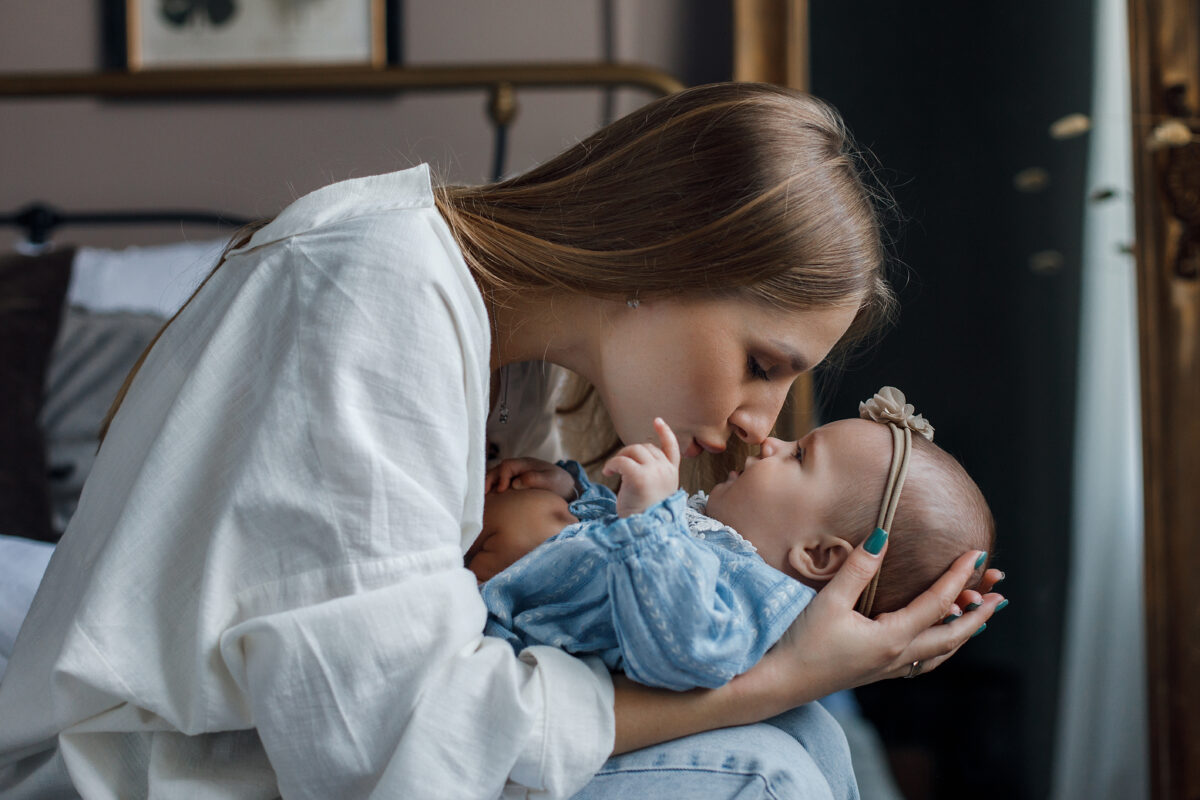 Γυναίκα κρατάει αγκαλιά το νεογέννητο μωρό της.