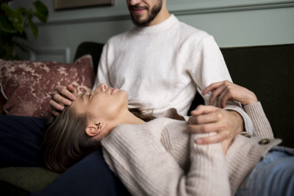 Κοπέλα είναι ξαπλωμένη στα πόδια του συντρόφου της και σκέφτεται.