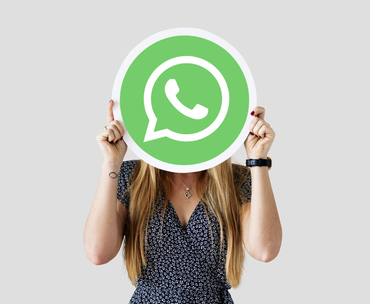 Γυναίκα κρατάει το logo της Whatsapp.